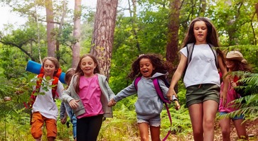 Boys and girls running in the forest together
