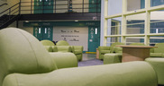 Green chairs and sofas in empty room.