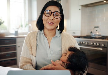 portrait of mother and video call with baby in kitchen of home for childcare or remote work