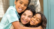 Boy and girl embrace older woman.