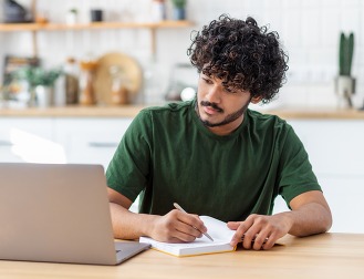 Concentrated young Asian man student using laptop computer for online education