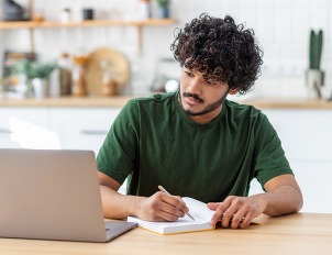Concentrated young Asian man student using laptop computer for online education