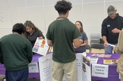 Young people resource fair booth talking with staff