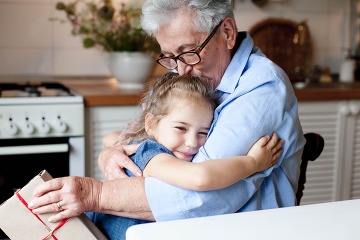 Grandmother congratulates child with gift box.