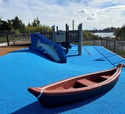 Playground with canoe toy and salmon slide.