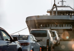 cars in line waiting to board a ferry boat