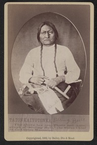 Half-length studio portrait of Sitting Bull seated holding pipe and tobacco bag. 