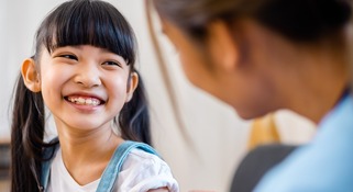 Childhood vaccination. Asian young woman doctor vaccinating little girl 