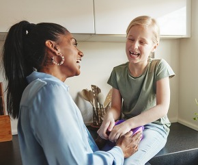 Mom and her little daughter laughing in their kitchen