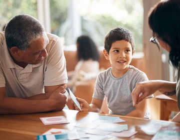 Home school, learning and parents support child with lesson and flash cards for education.