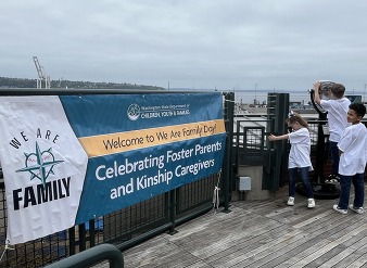 we are family day sign, three children off to the side looking at the cityscape