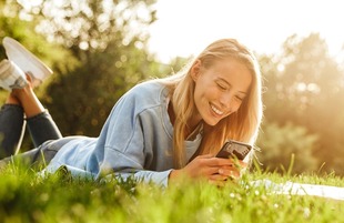 Portrait of a cute young girl laying on a grass at the park
