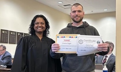 man standing next to judge smiling holding a certificate