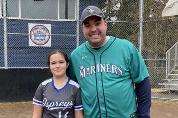 foster dad and youth smiling at basbeball game