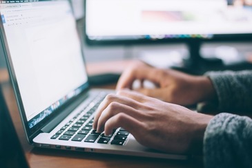 hands typing on a computer keyboard