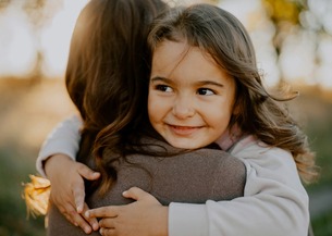 daughter hugging mom and smiling