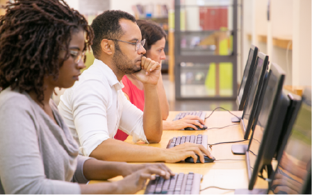 Multiple people working at computers next to each other