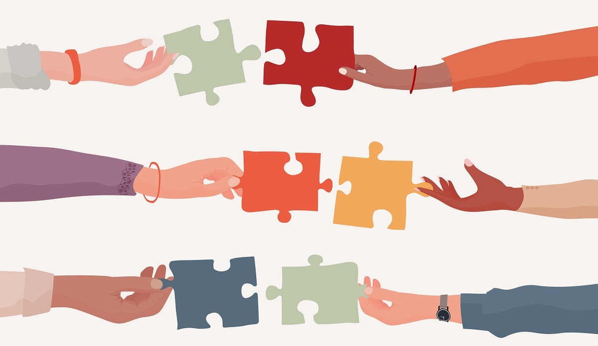 Illustration of several hands with different skin tones assembling puzzle pieces.