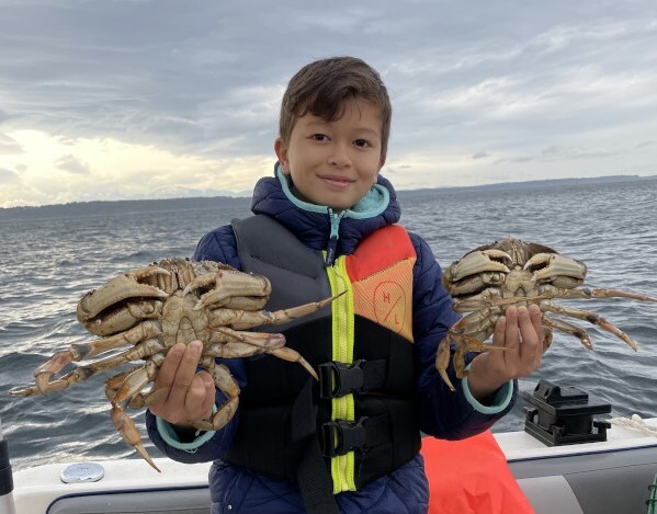 Boy holding two Dungeness crab