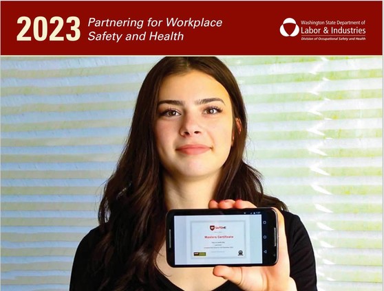 The cover of L&I's 2023 Safety & Health Calendar: a student with long brown hair holds a cell phone showing a "Safe Me" certificate