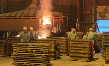 Worker pouring molten metal, not wearing proper safety mask