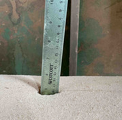 measuring ruler stuck in sawdust