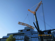A section of a crane is lifted in the air.