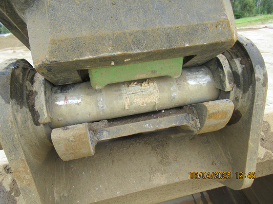 A green safety latch can be seen on excavator equipment.