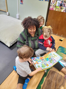 photo of child care center worker reading with a child