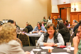 Room with council and community members sitting at tables