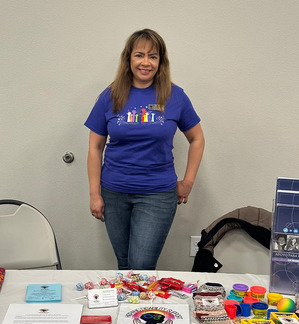 Photo of Gabriela working at a table during an event. 