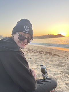 Photo of Riley smiling on a beach. 