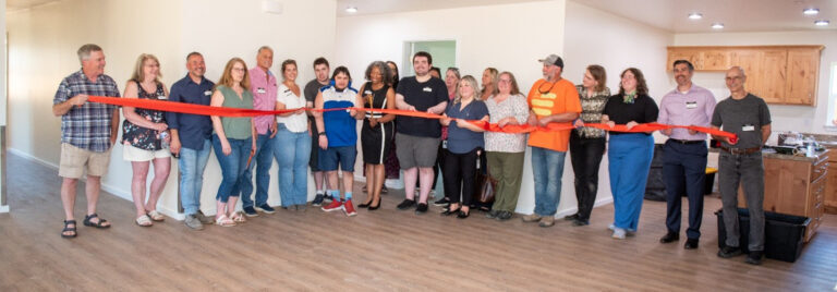 A group of people at a ribbon cutting for new home