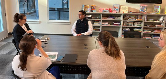 Director Nguyen visits talks to four women at a child care center.