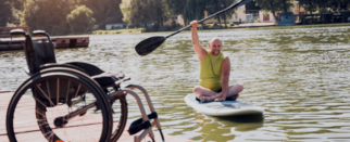 Man on paddleboard with wheelchair in the foreground