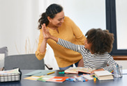 Adult and child high-fiving at a table