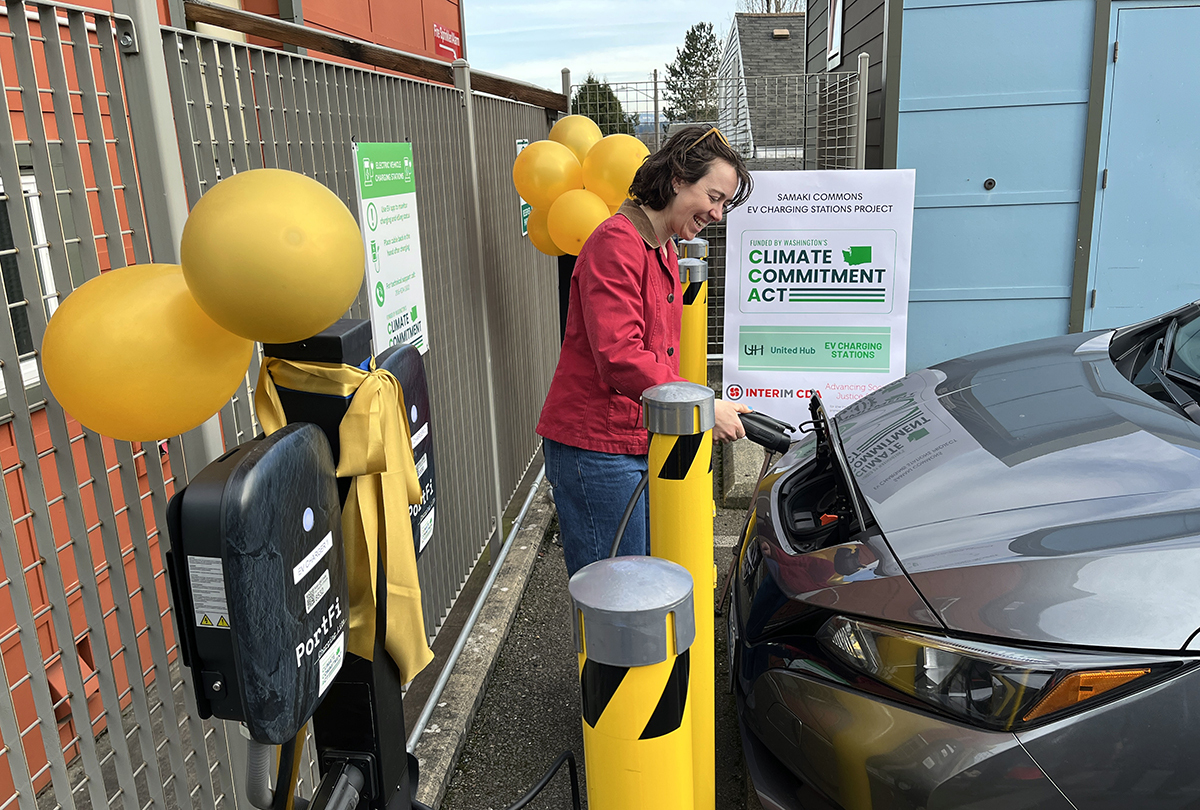 A woman charges an EV at the Samaki Commons EV Charging Station Project.