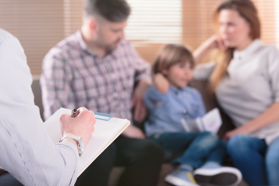 A family sits with a provider who is taking notes.