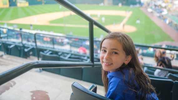 Young girl smiling at baseball stadium