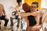 Two people hug during a parent support group meeting.