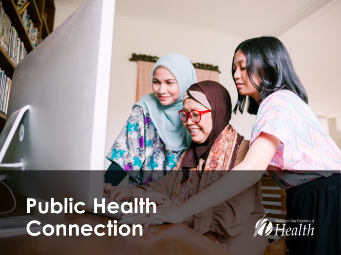 Three family members gathered around a computer