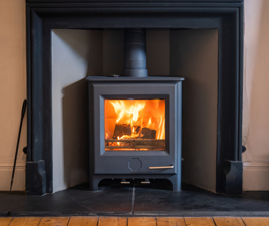 A fire burns inside a woodburning stove to help heat a home.