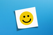 Happy face on note with blue background