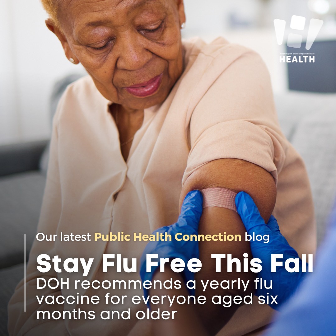 Older woman receiving a bandage over the vaccine injection site on her upper arm.