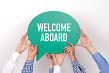 Group of people holding the WELCOME ABOARD written speech bubble