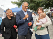 Secretary Shah (left) and Governor Jay Inslee (center) engage with WIC participants at the 50th anniversary event