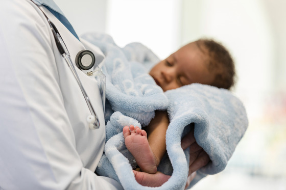 A doctor holding a newborn baby.