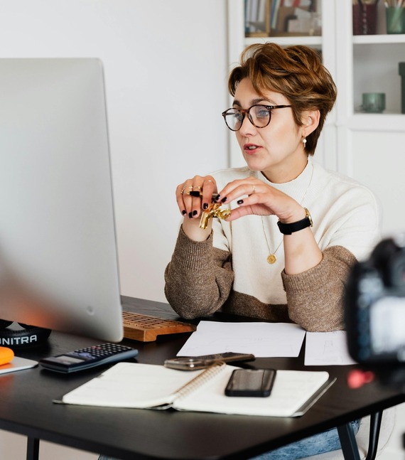 Confident elegant lady in eyeglasses hosting webinar