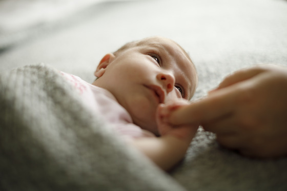 Newborn holding parent's finger
