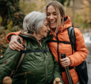 Adult woman hugging an older woman while hiking.